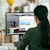 Person sitting at desk working at a computer that has 3D Warehouse and SketchUp open on the screen.