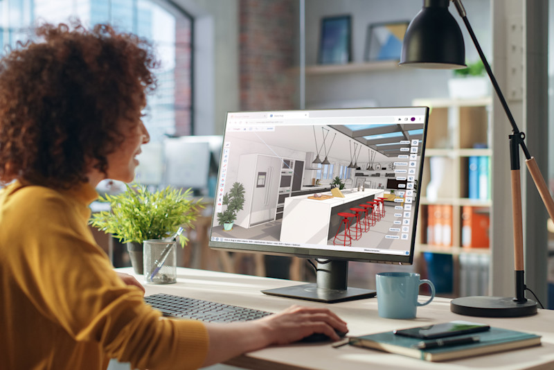 Eine Frau in einem Büro nutzt Trimble SketchUp, um ein 3D-Innendesign für eine moderne Küche zu erstellen.