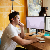 A man working on a computer at his desk. 