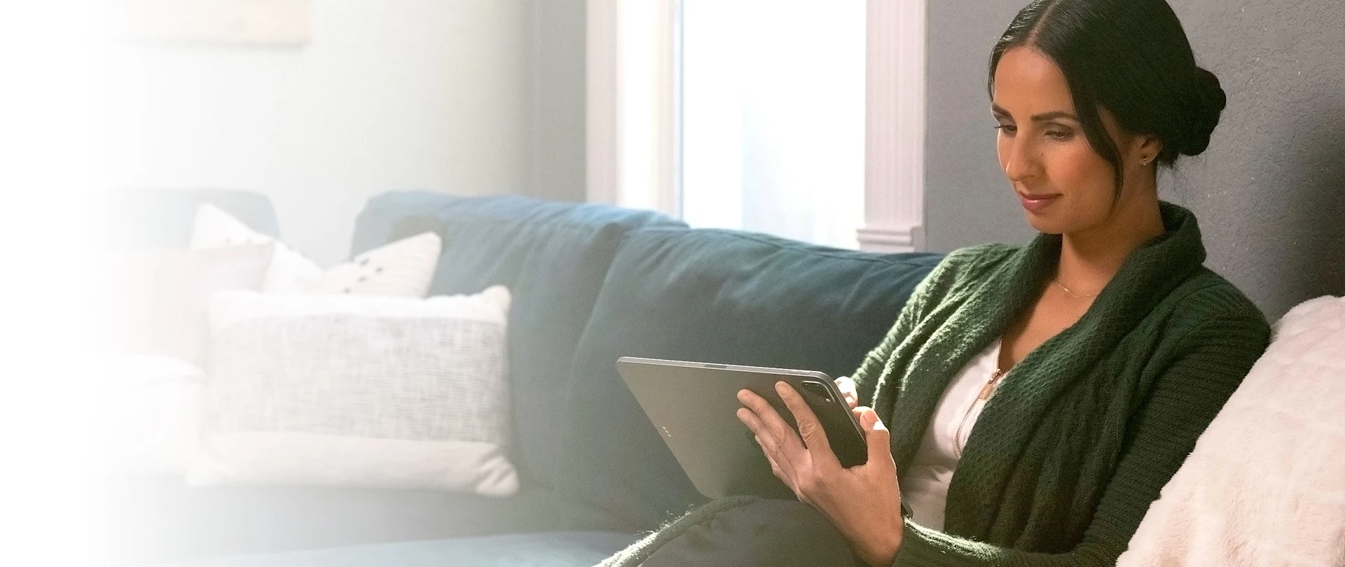 Woman sitting on a couch working with SketchUp for iPad.