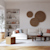 A modern minimalist living room featuring a white sectional, a low wooden coffee table, and three circular woven wall art pieces.