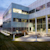 Modern glass exterior of Trimble’s corporate headquarters in Westminster, Colorado, with an outdoor patio and seating at dusk.
