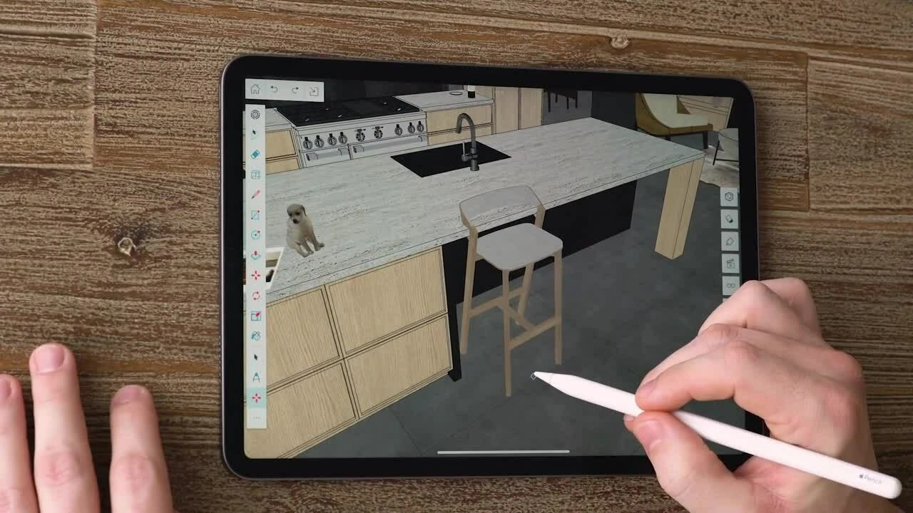 A person uses an Apple Pencil to edit a 3D kitchen design on an iPad using Trimble SketchUp, featuring a small dog on a counter.