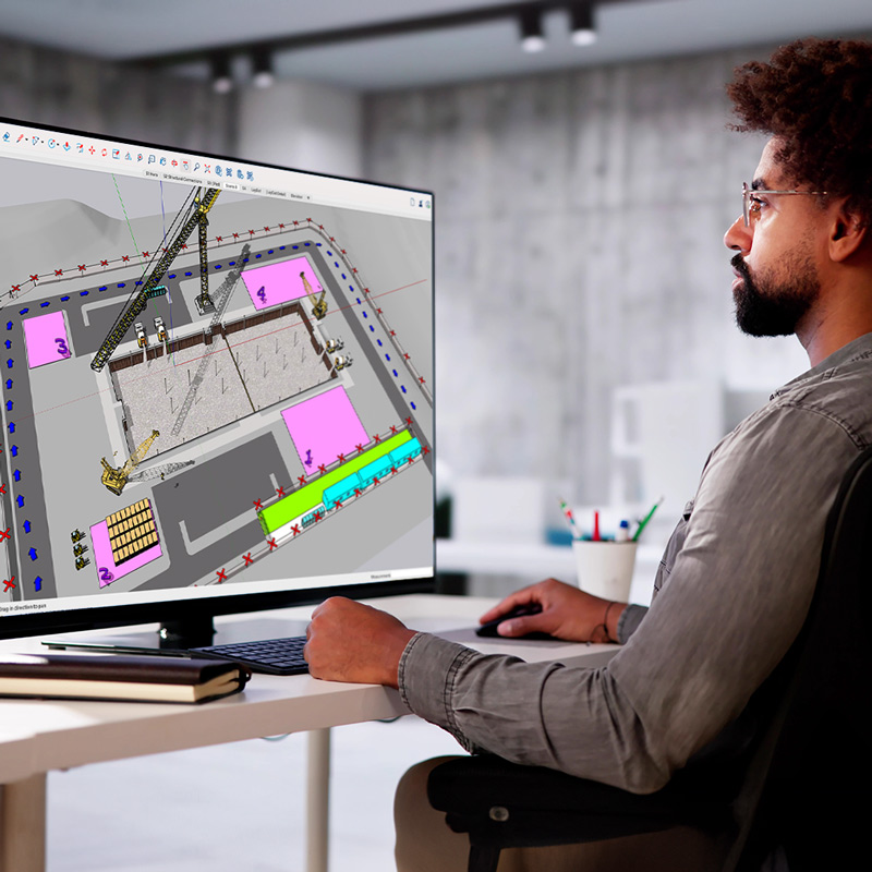Eine Person sitzt an einem Schreibtisch vor einem Computerbildschirm mit der 3D-Konstruktionssoftware SketchUp