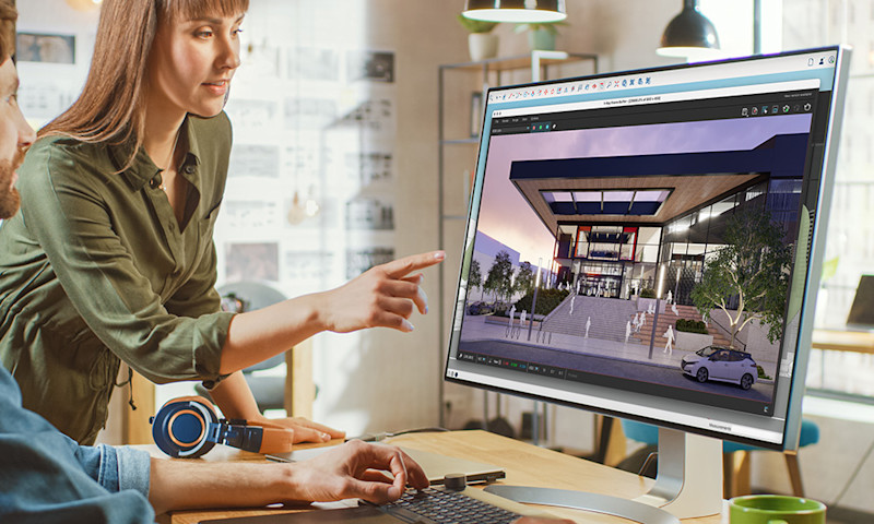 Zwei Menschen begutachten auf einem großen Computermonitor ein Architektur-Rendering in Trimble SketchUp.