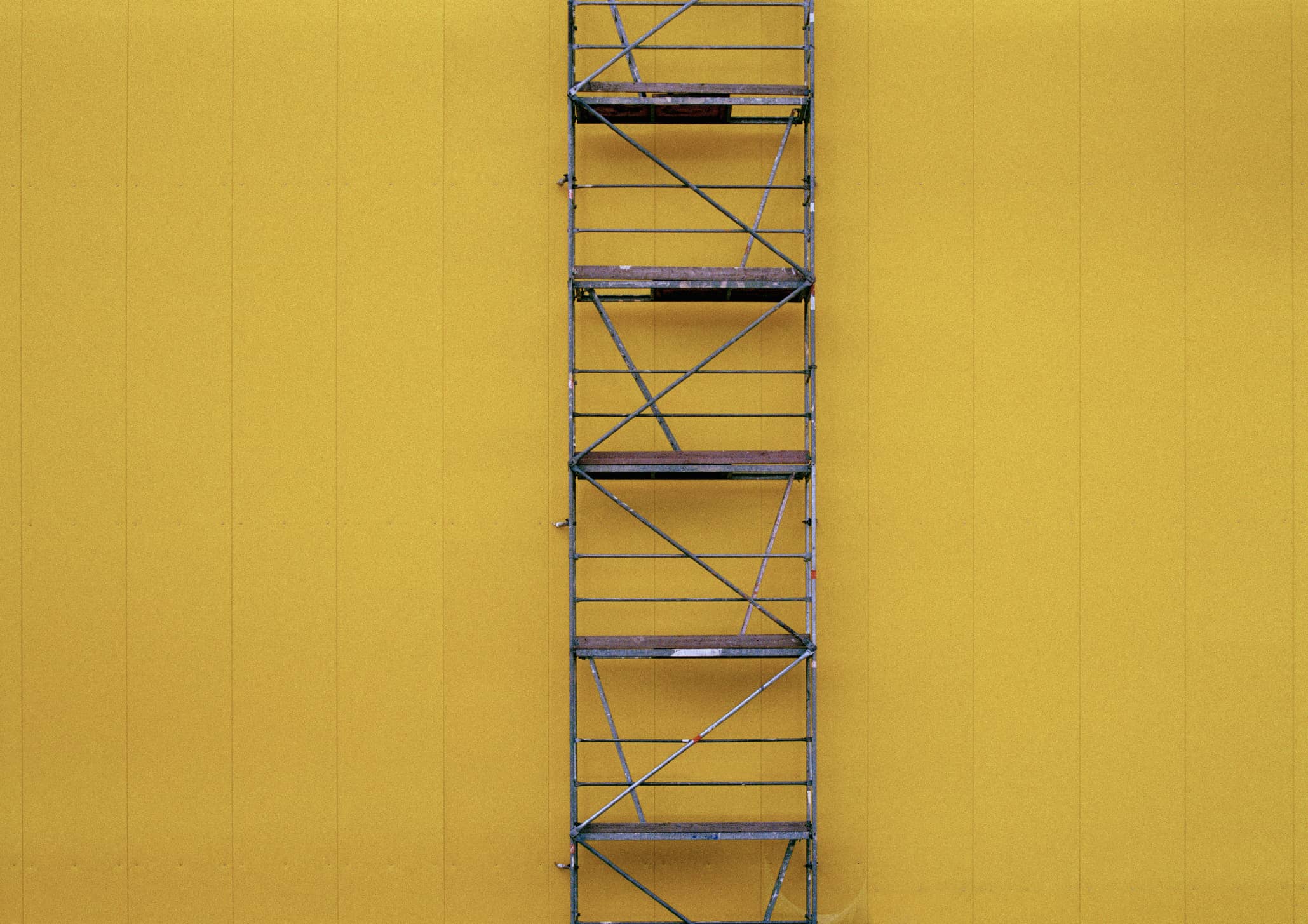 Scaffolding against a yellow wall
