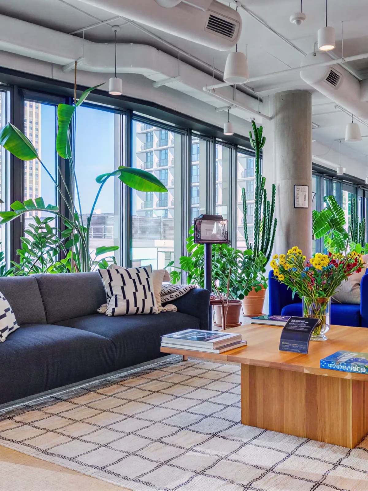 The Warsaw office, with sofas and plants along a wall of city windows