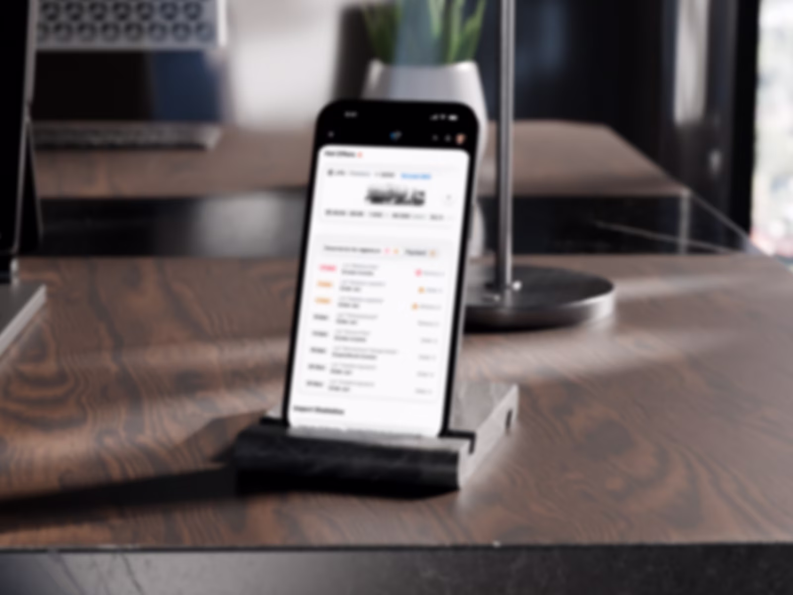 GT mobile app on a phone standing on a desk (blurred for NDA).