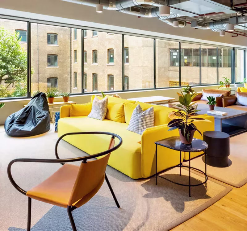The London office, with yellow sofas beside a window onto the street