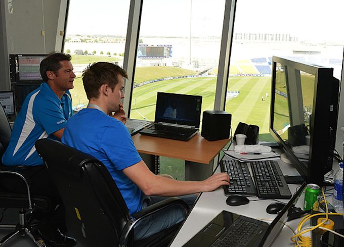 A close-up of a TV umpire watching multiple replay screens