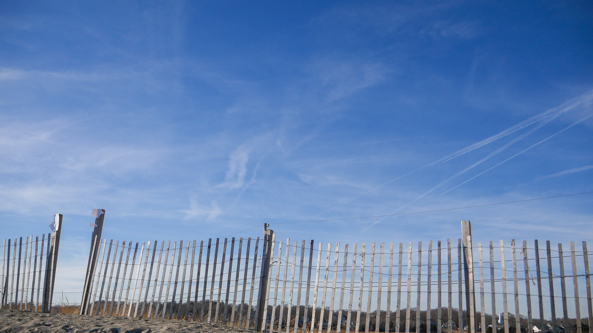 beach fence, bright blue sky