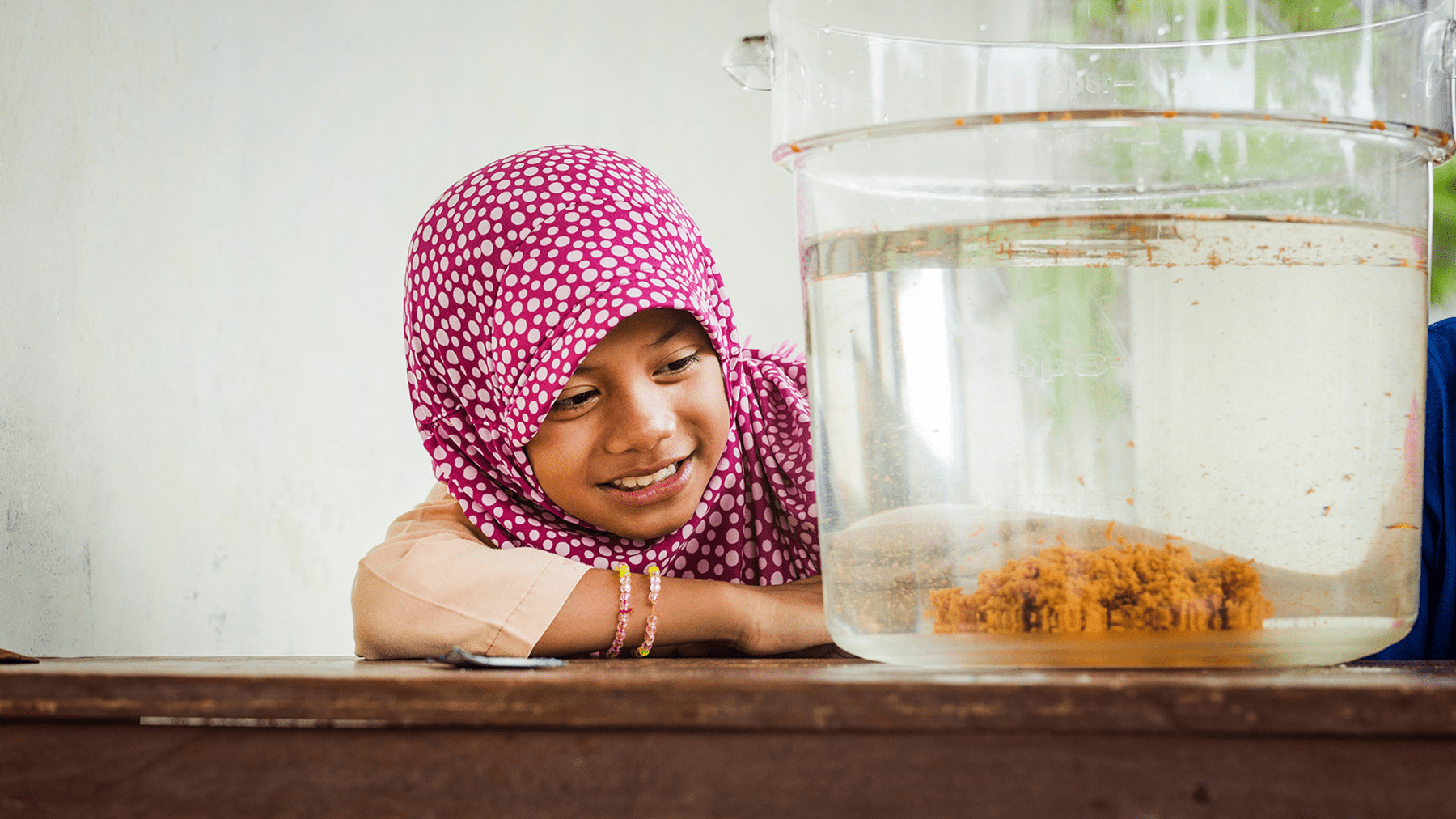 A little girl watches how the clean drinking water process Is happening
