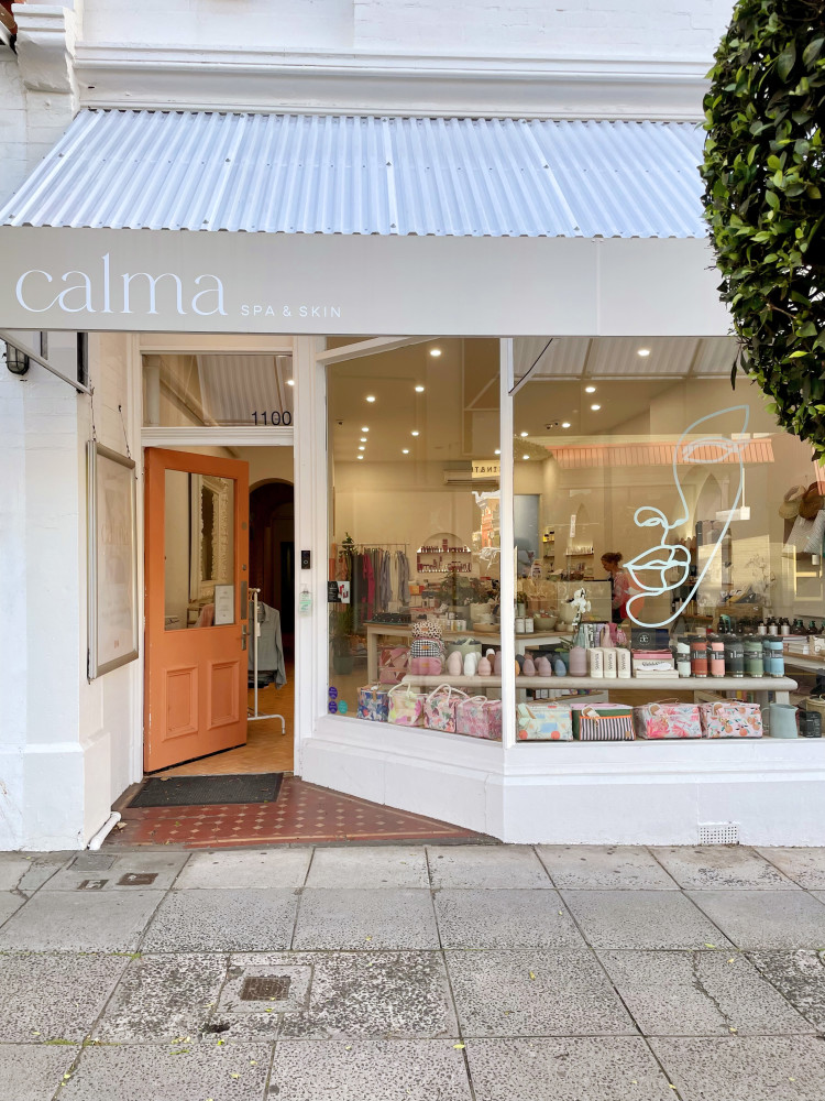The outside of Calma Spa in Melbourne, the inside is lit up and the door of the Spa is open