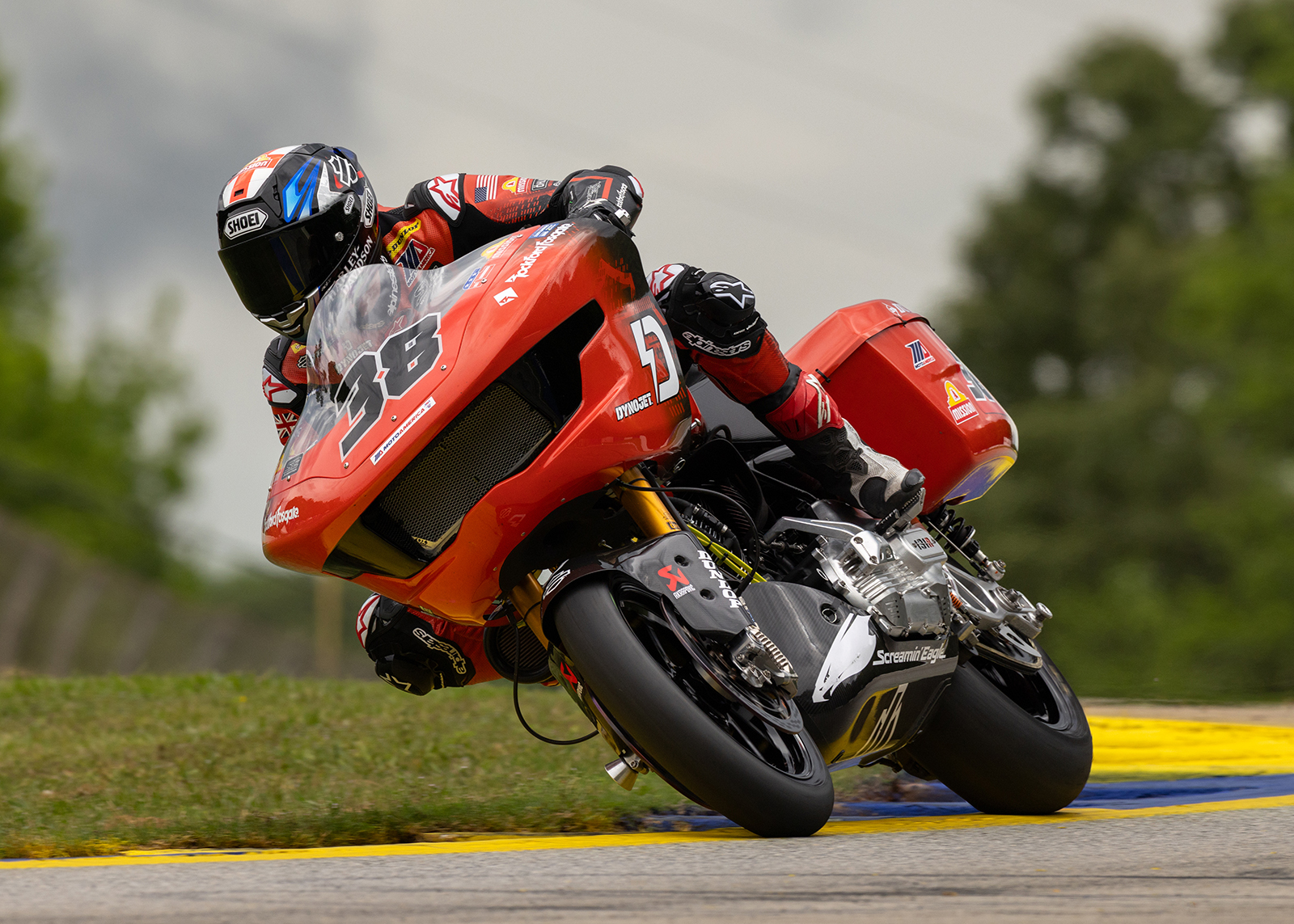 A closeup of Bradley Smith riding his bright orange bagger around a curve on the track.  