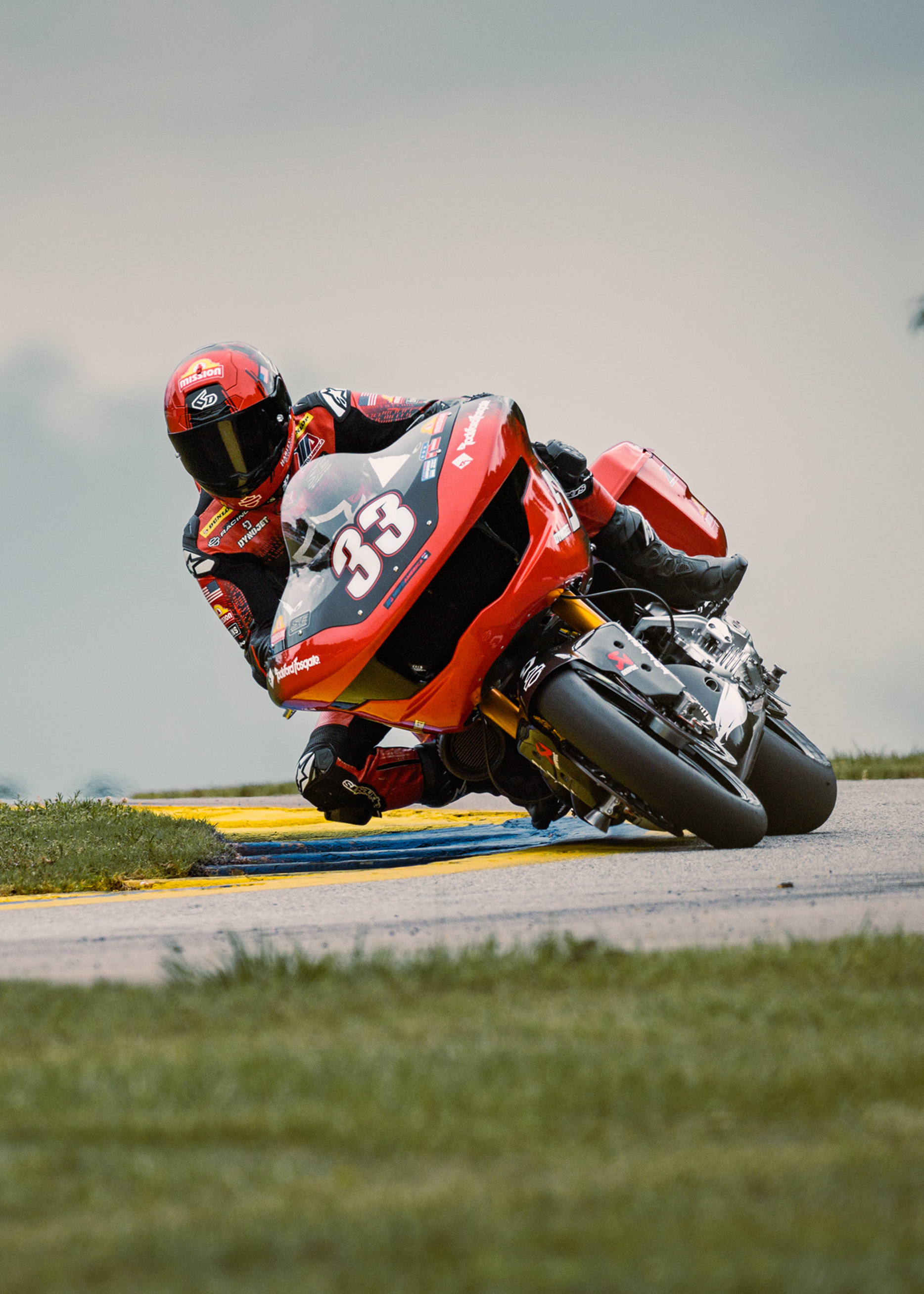 Kyle Wyman leans his number 33 Harley-Davidson Road Glide into a corner on a racetrack.