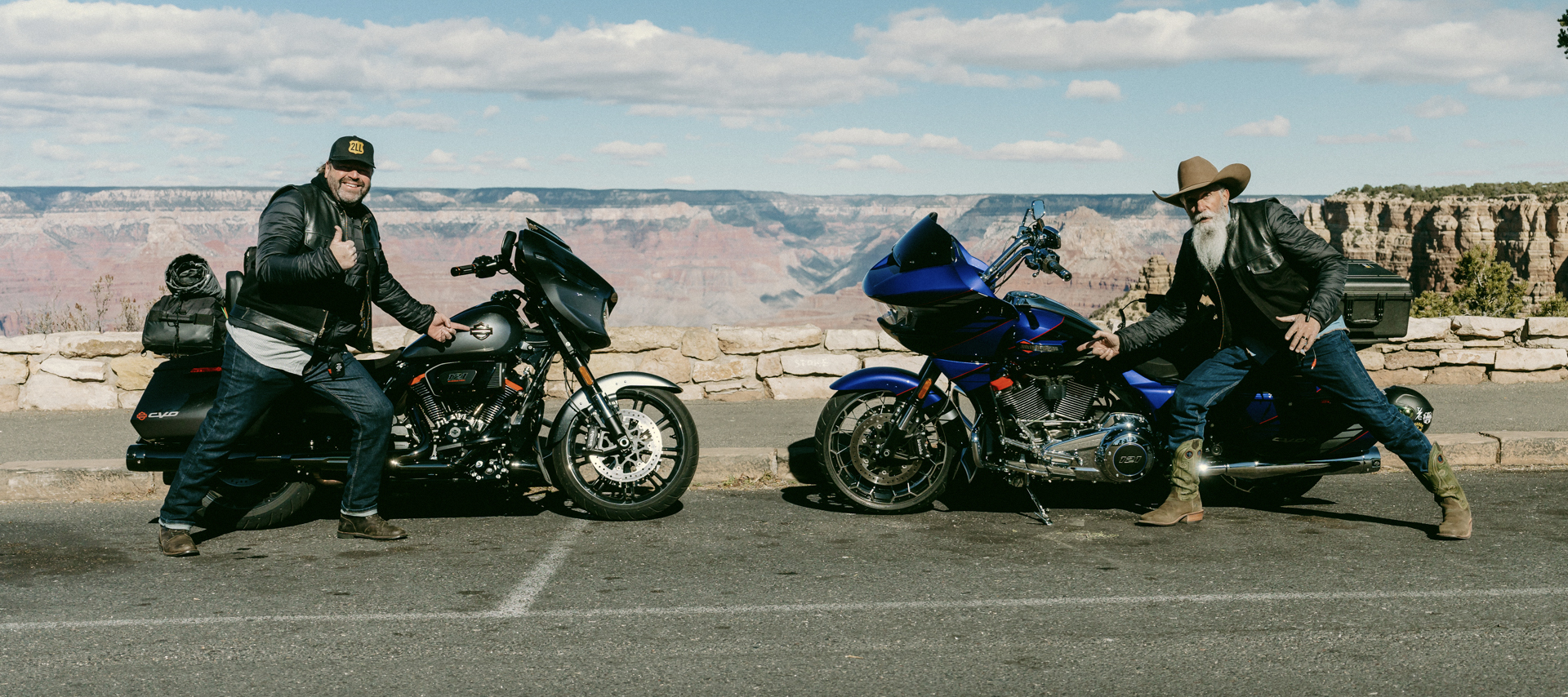 Two men posing with their bikes at the edge of a canyon