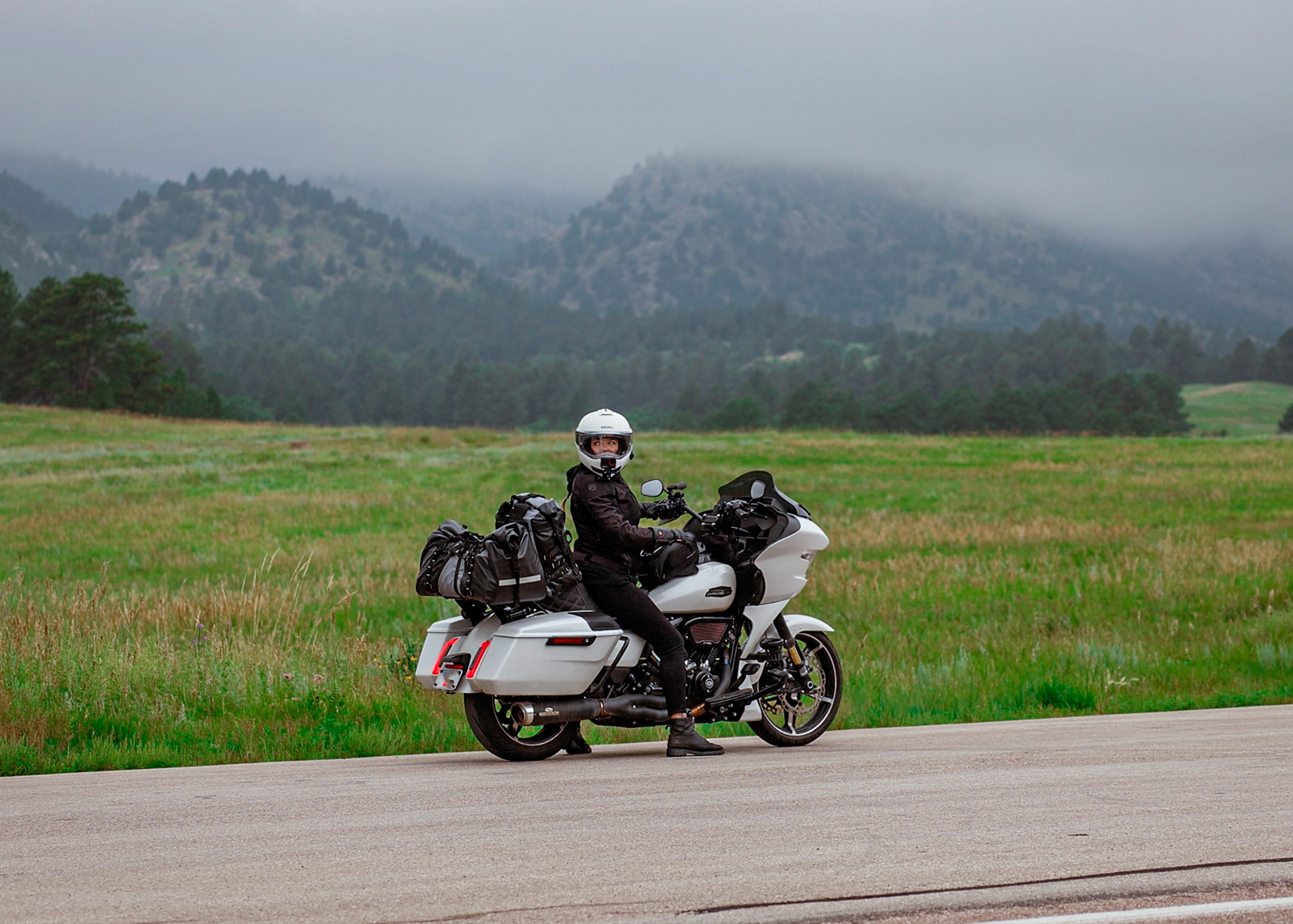 The author in full gear on a white touring motorcycle, parked on a foggy mountain roadside.