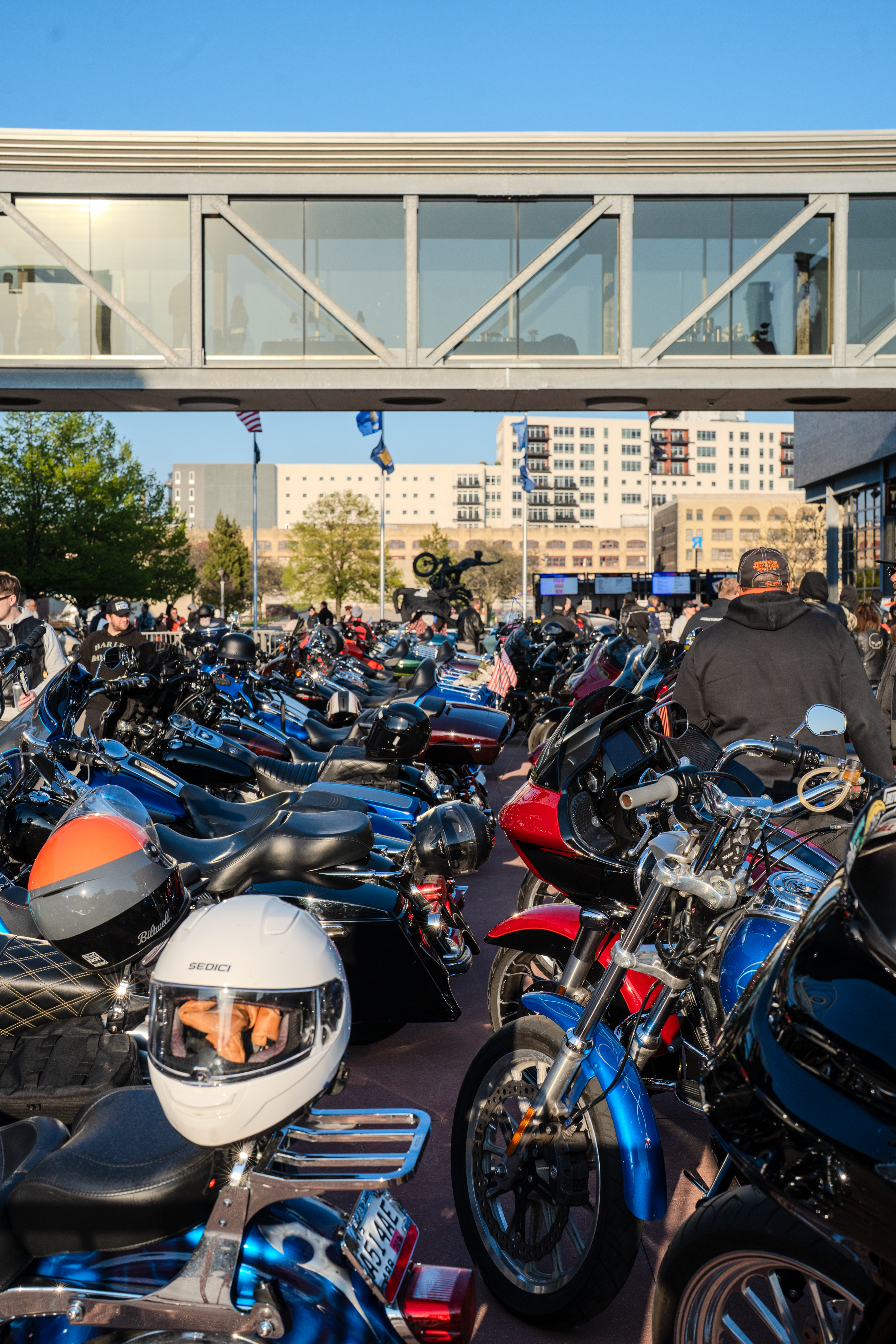 Fila apretada de motocicletas estacionadas debajo de una pasarela peatonal