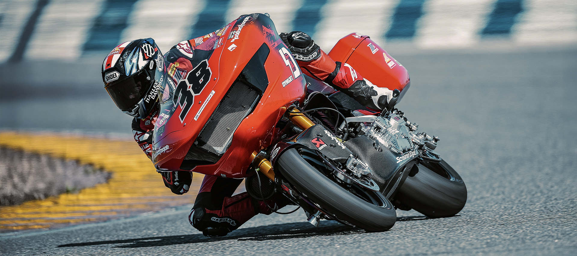 Bradley Smith leans his number 38 Harley-Davidson Road Glide into a corner on a racetrack.