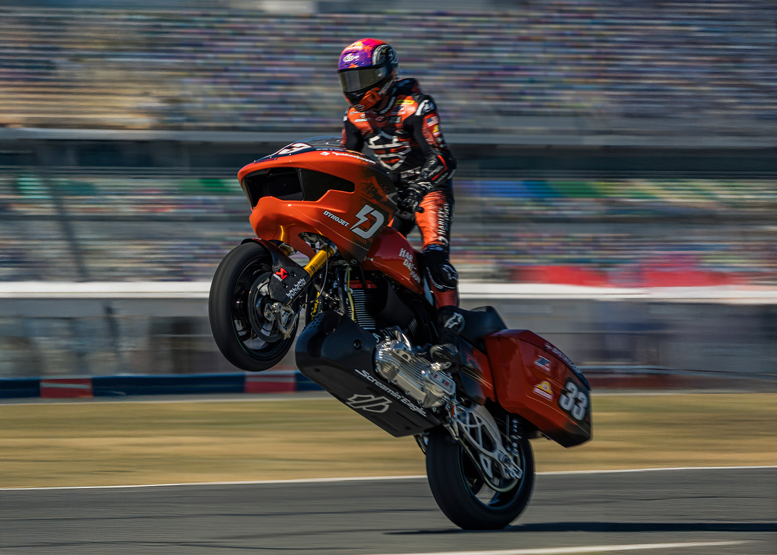 Kyle Wyman wheelies his number thirty-three motorcycle after finishing in first place