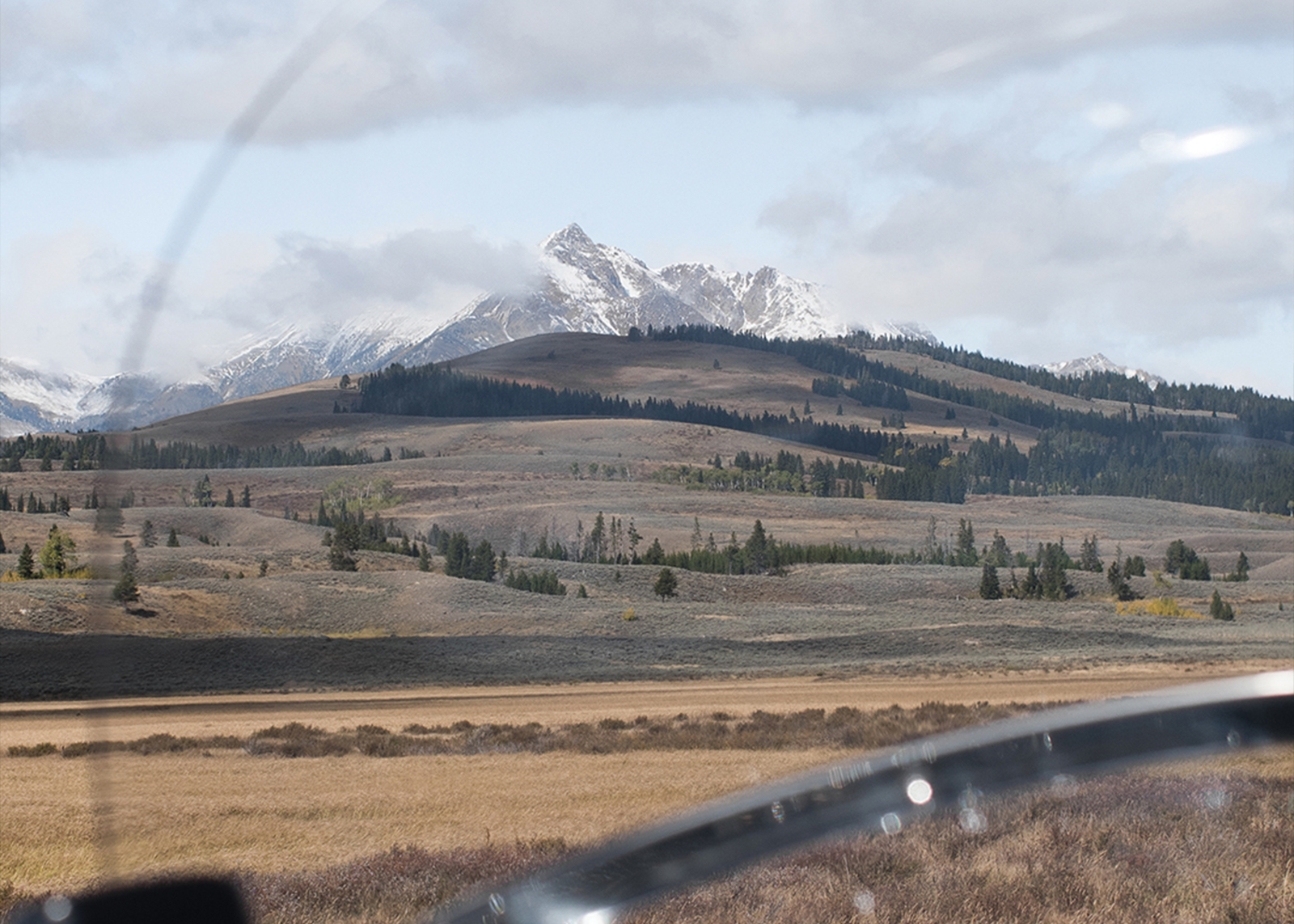 A mountain in the distance through the windshield of a motorcycle 