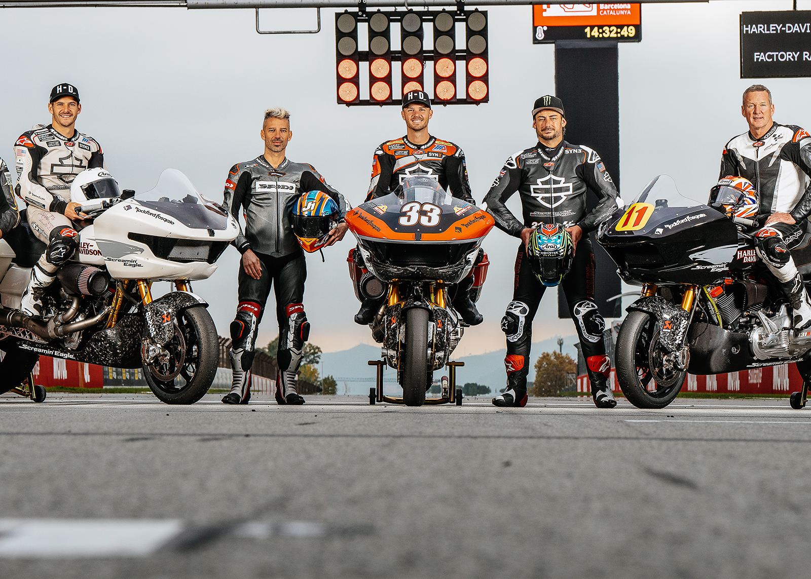 A group of racers poses in front of race-spec Harley-Davidson Road Glides at the MotoGP x Harley-Davidson test at the Barcelona GP in November 2024.  