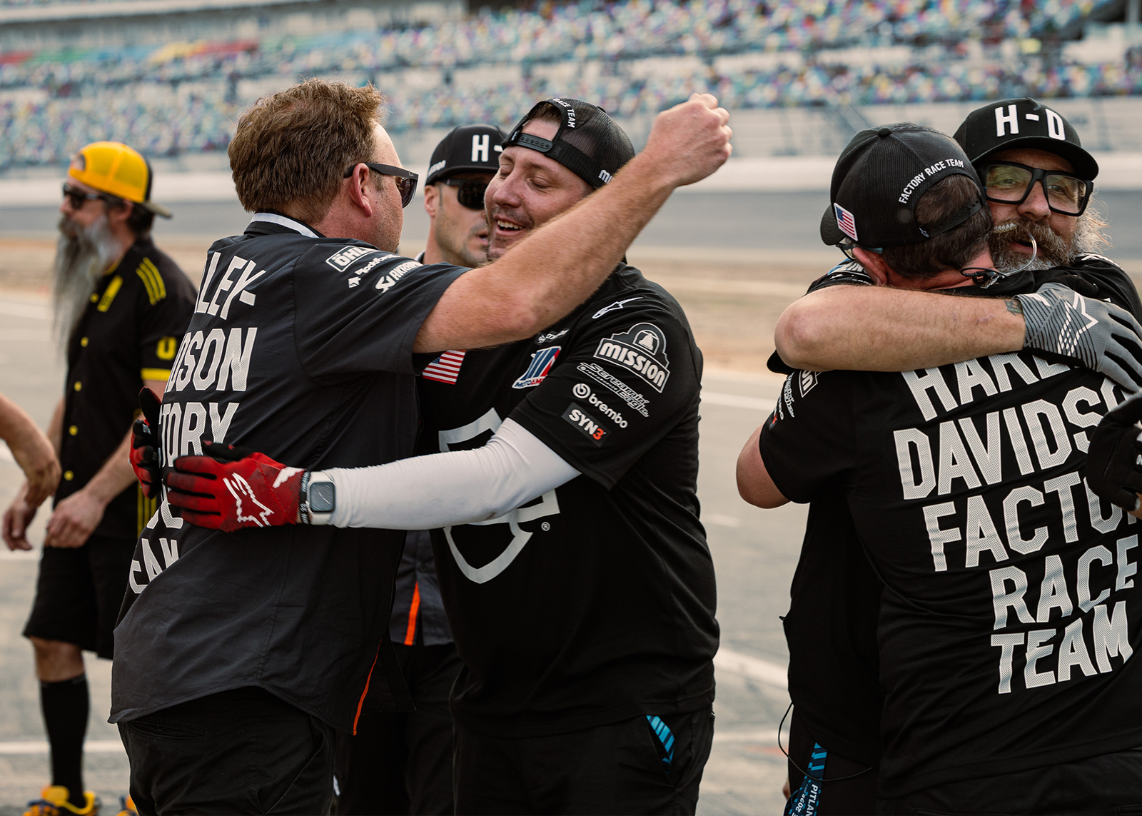 Harley-Davidson Factory Race Team crew members hug each other in celebration.