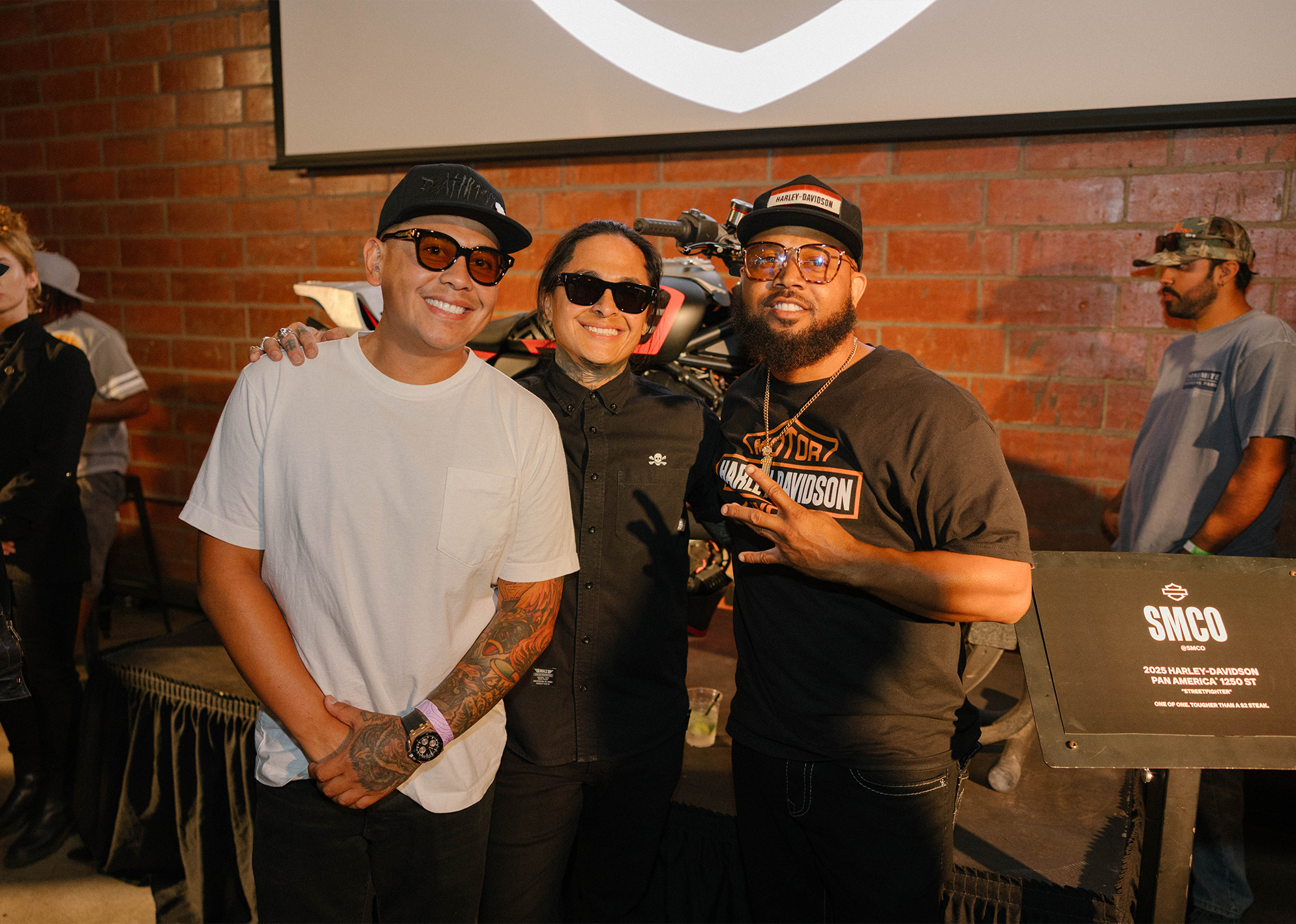 Shaun and Aaron Guardado of SMCO pose with a third person together in front of the custom Harley-Davidson Pan America ST during the Harley-Davidson Fight Night event.
