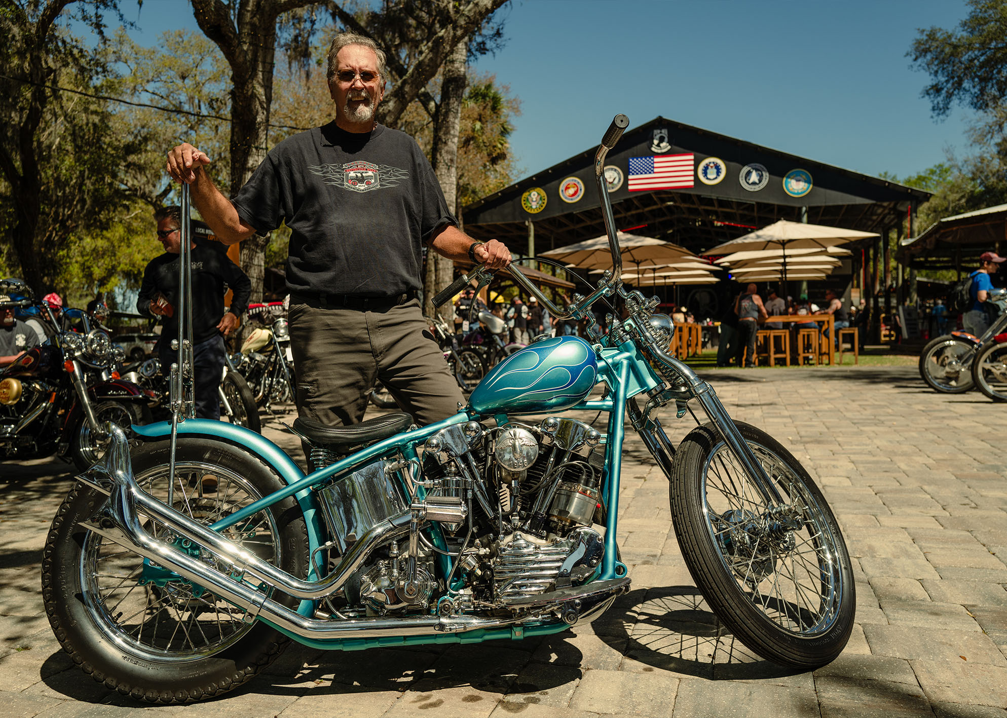 A man poses with his blue flamed knucklehead 
