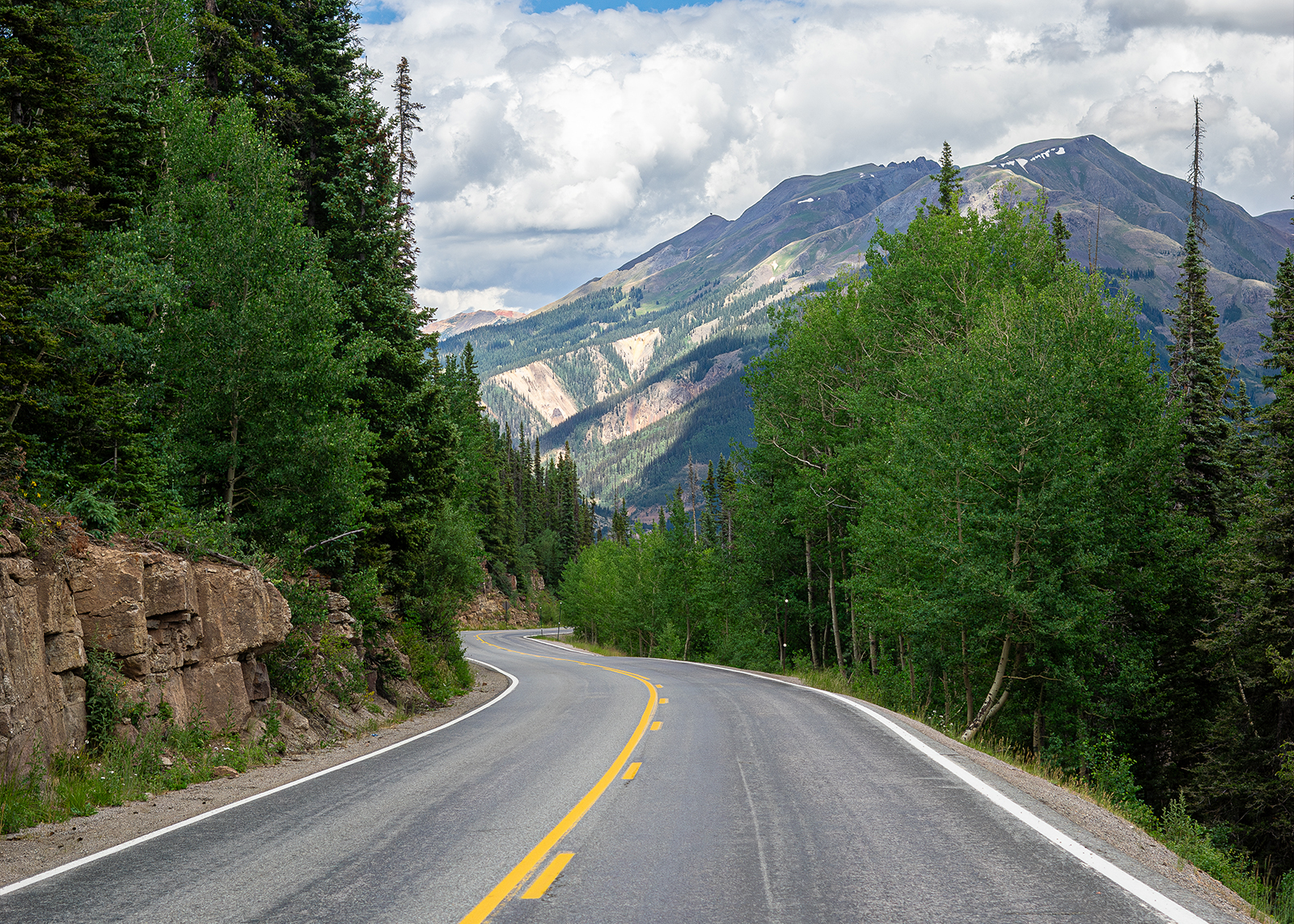 A two-lane road leads to the base of a mountain