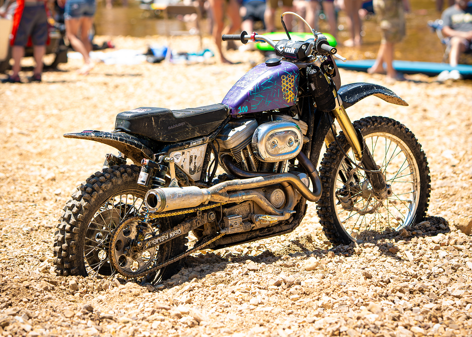 A bike, covered in mud, standing half buried in the dirt.