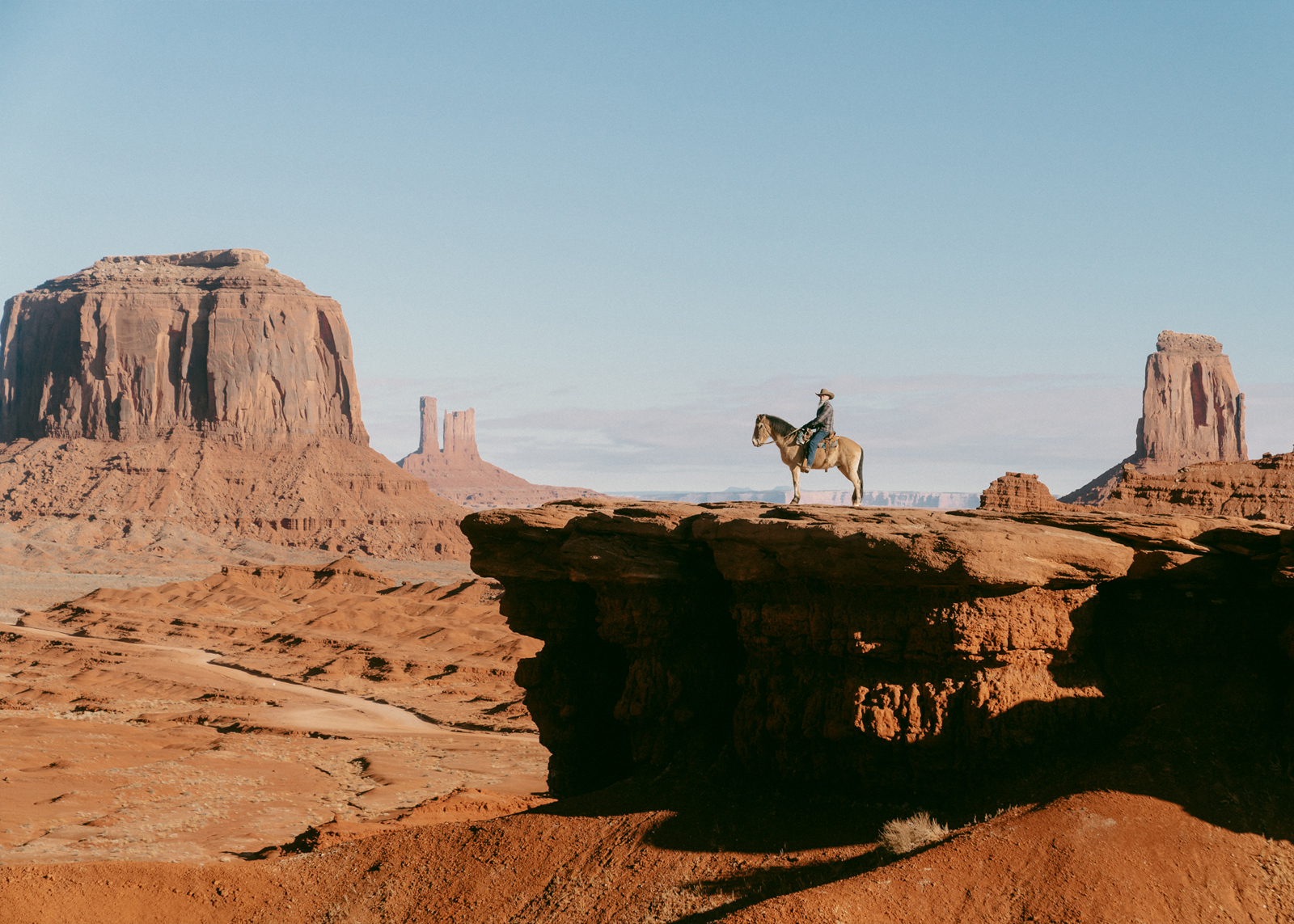 Man on a horse at the edge of a small cliff
