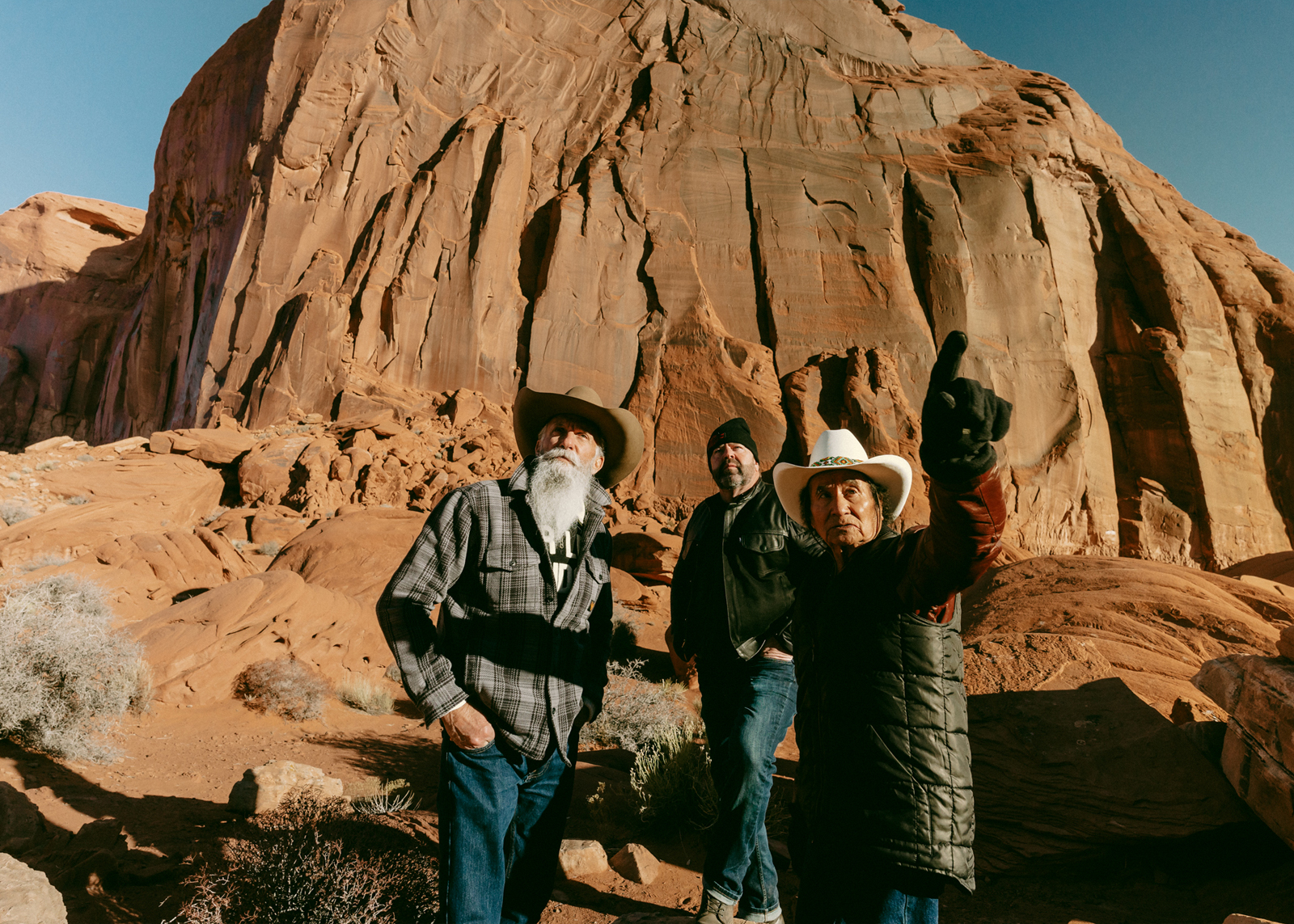 Three men at the base of a large rock formation