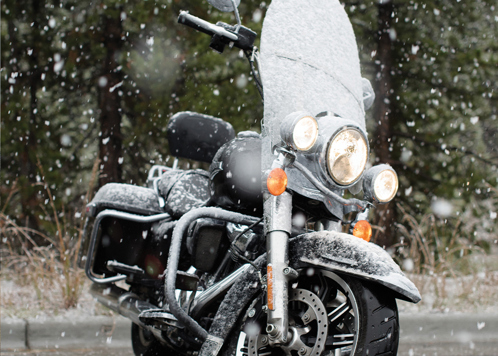 Snow starting to fall and sticking to a parked motorcycle