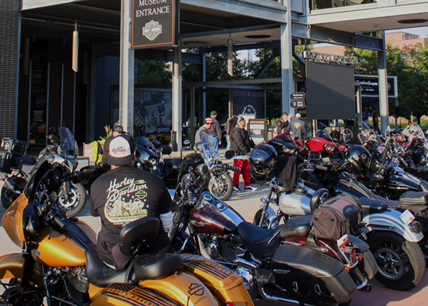 Motorcycles parked outside building entrance with people gathered nearby