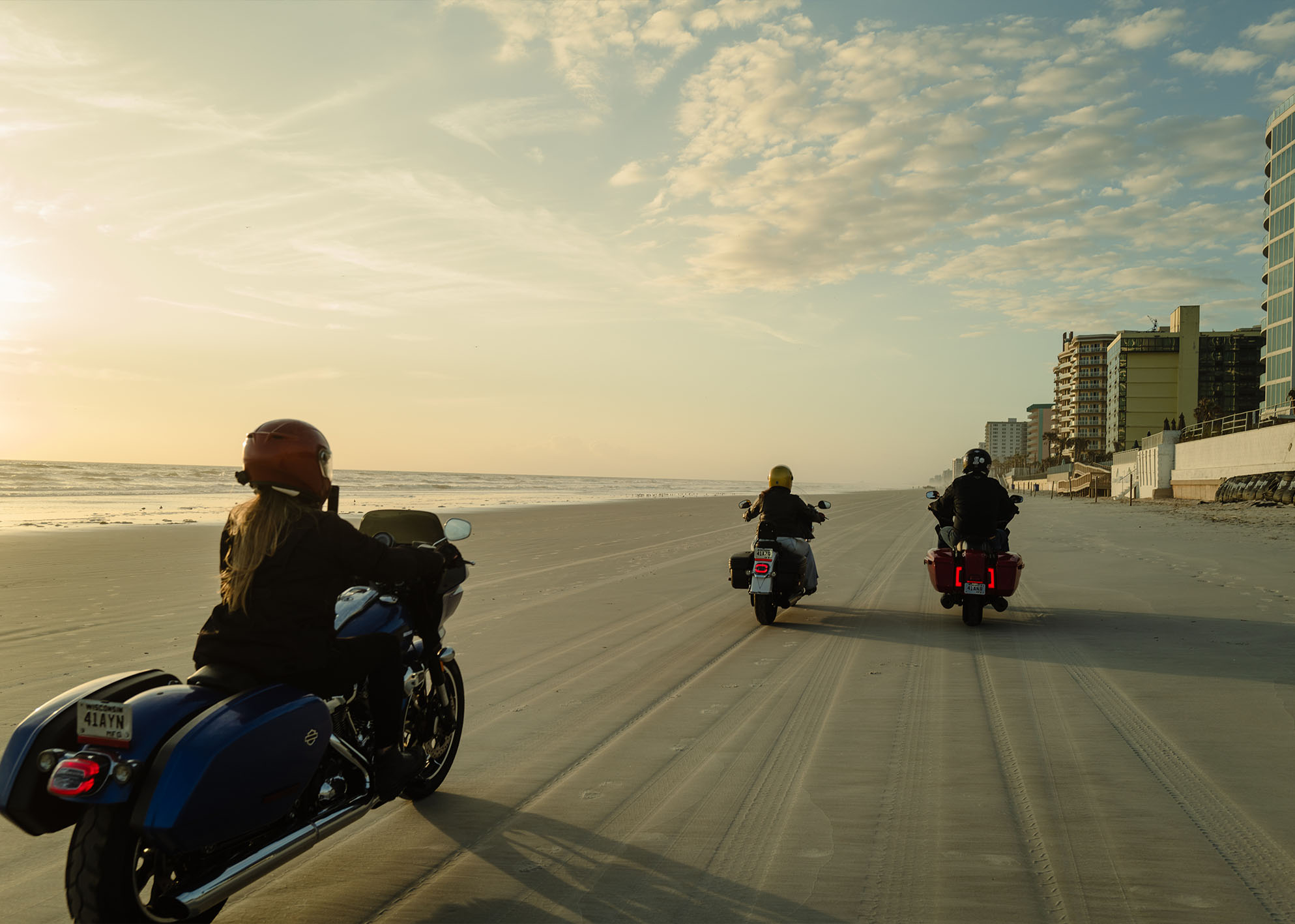 A group of riders make their way down the beach at sunrise 
