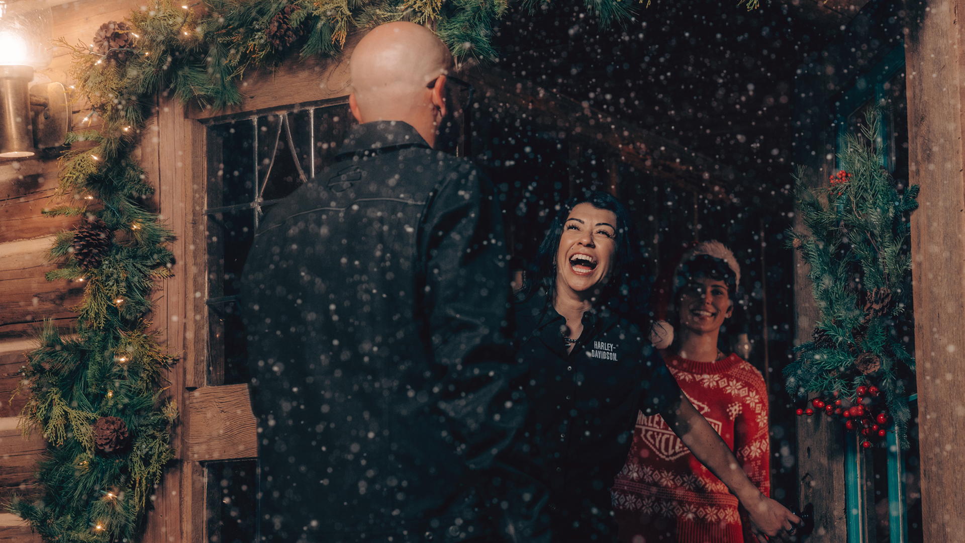 woman greeting man standing on porch decorated for christmas