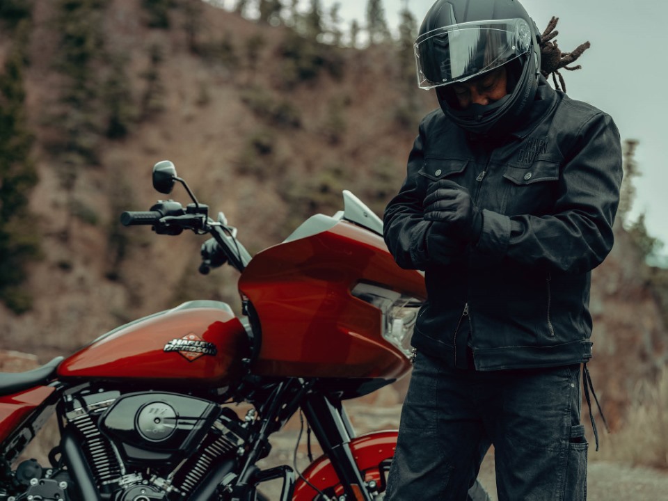 rider in full riding gear standing next to motorcycle