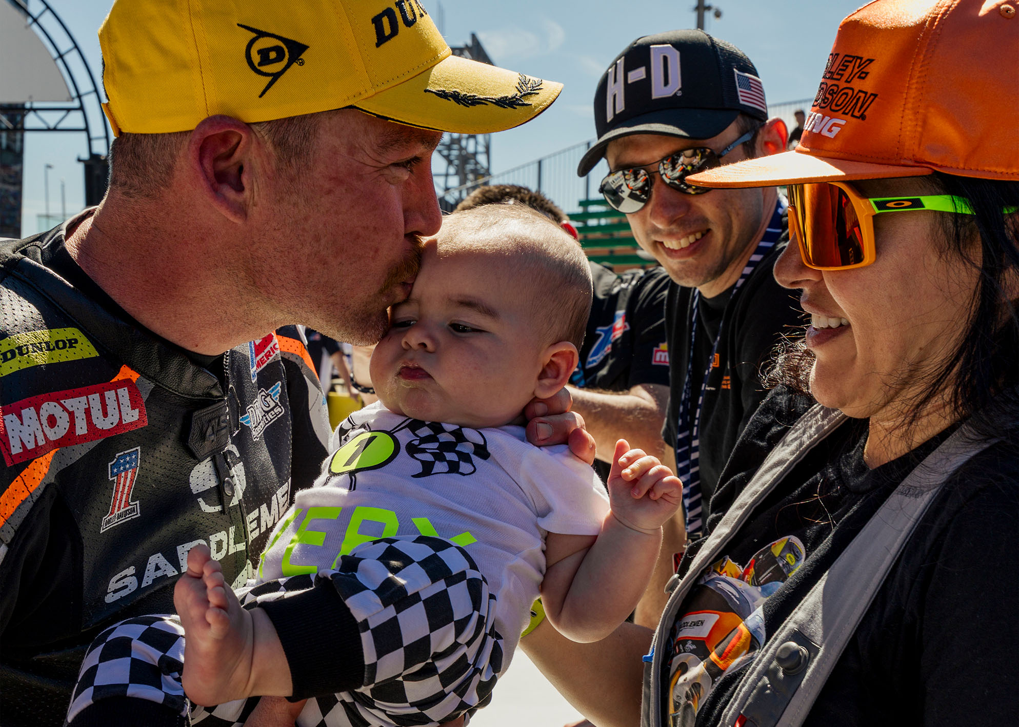 Cory West kisses his infant in Victory Circle