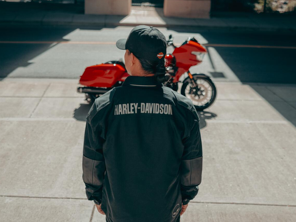 Woman standing and looking at a Harley-Davidson motorcycle