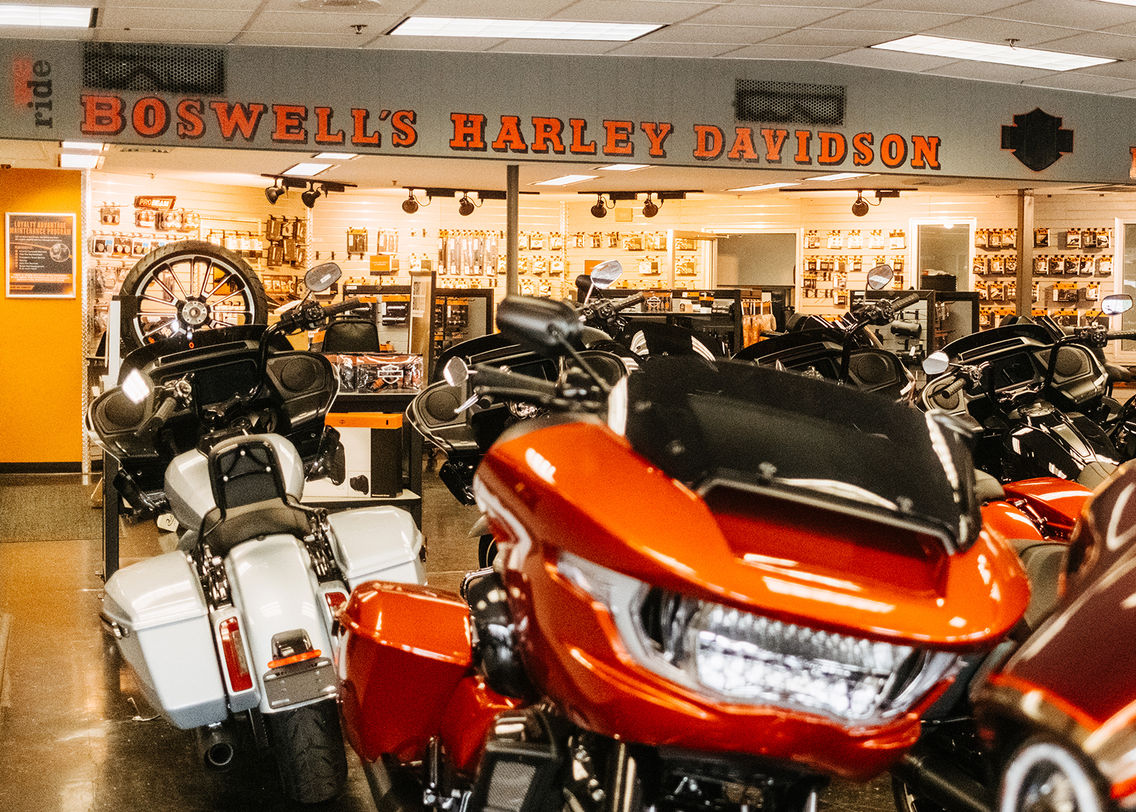 The interior of Boswell’s Harley-Davidson with bikes on the showroom floor and accessories in the background.