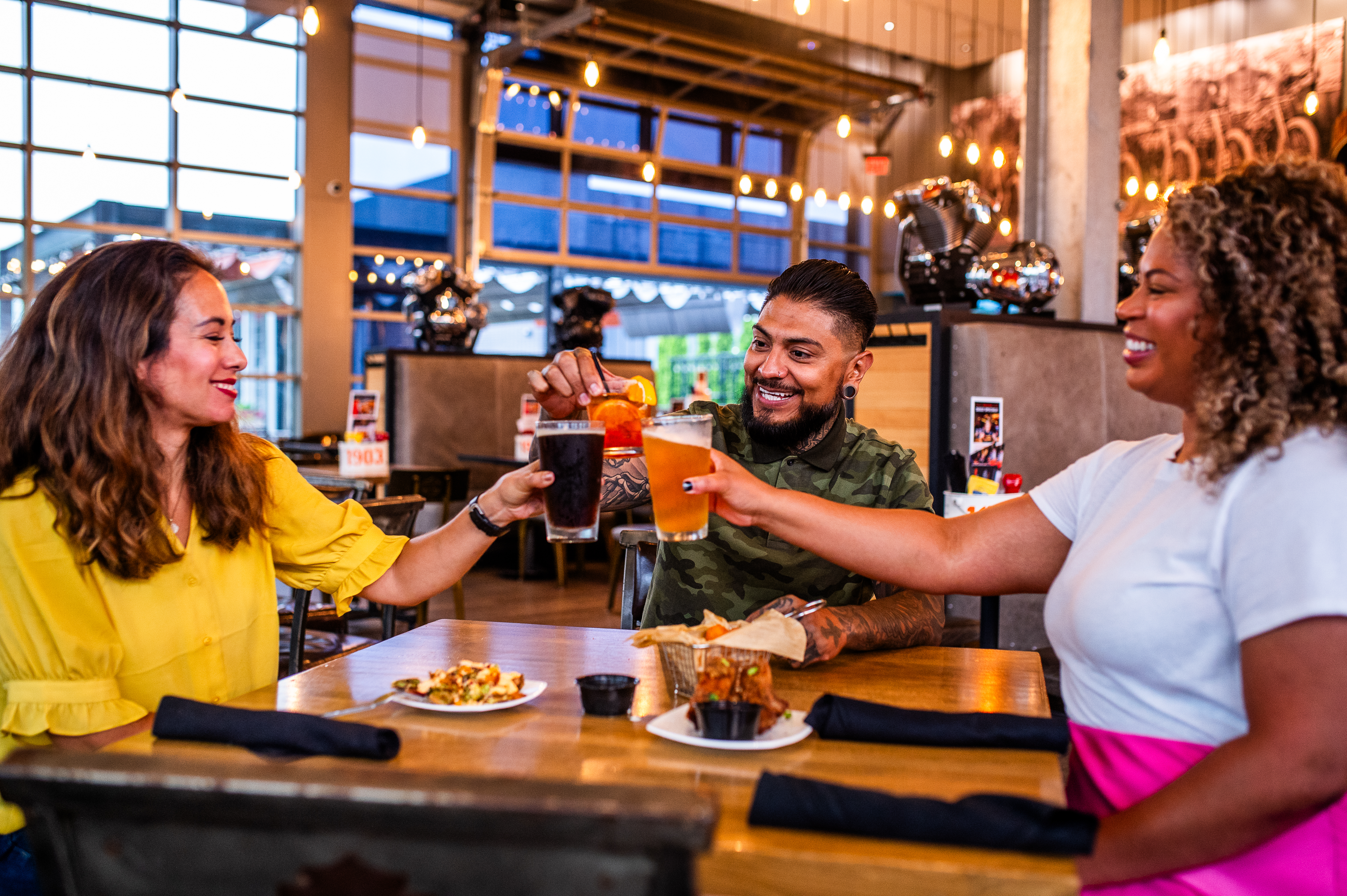 3 people with drinks at a table