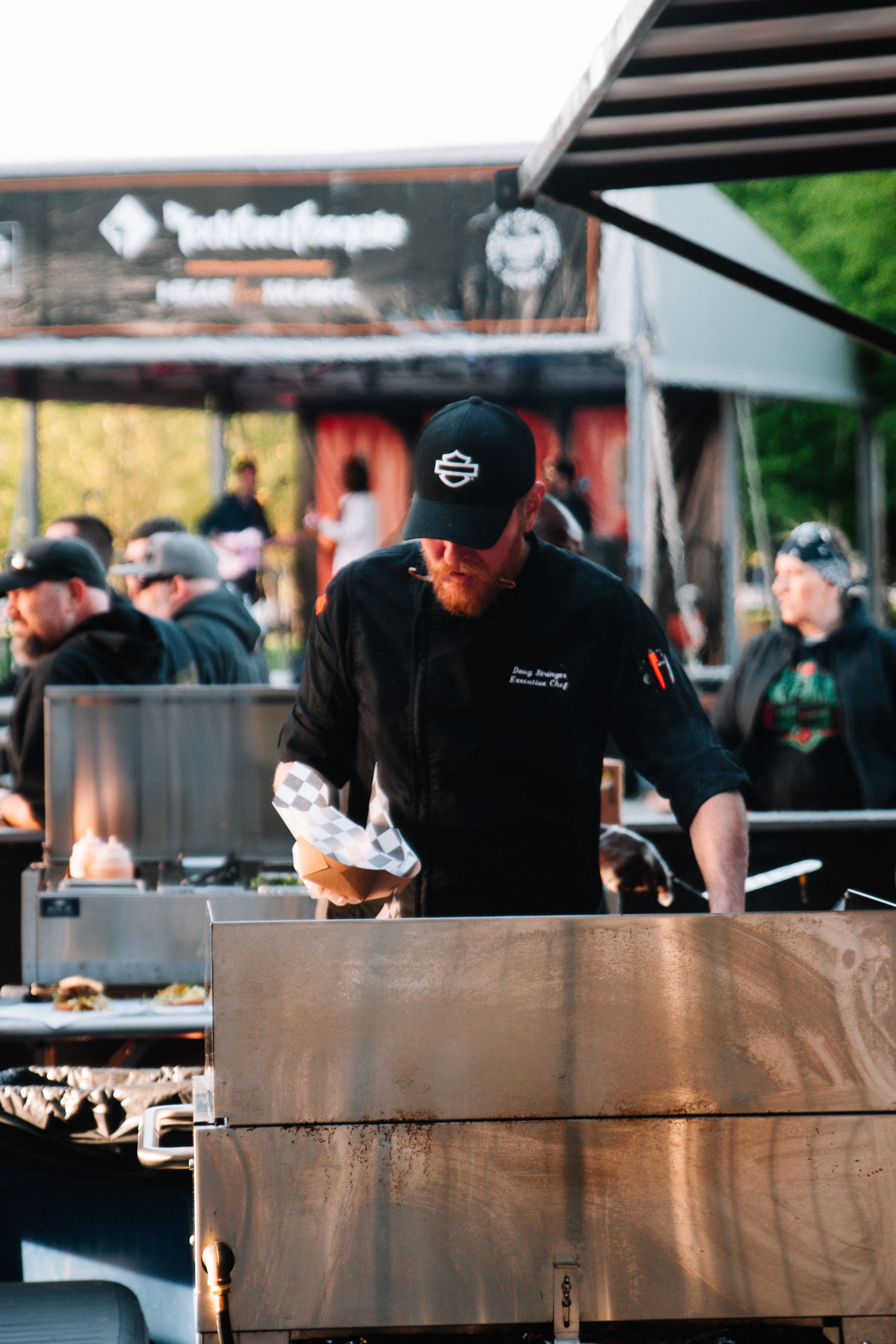 Chef cocinando en una estación de parrilla en un evento al aire libre