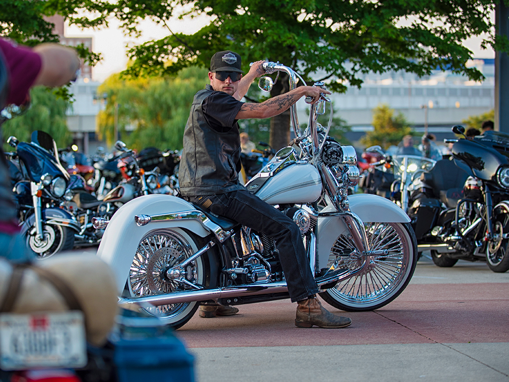 Person on custom motorcycle at outdoor bike gathering