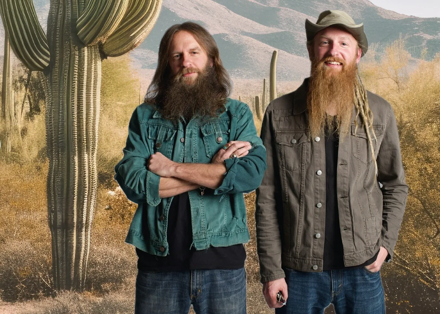 Two people with long beards standing in front of desert cacti backdrop