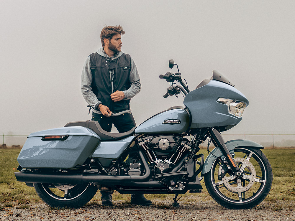 Piloto em pé ao lado da motocicleta Road Glide