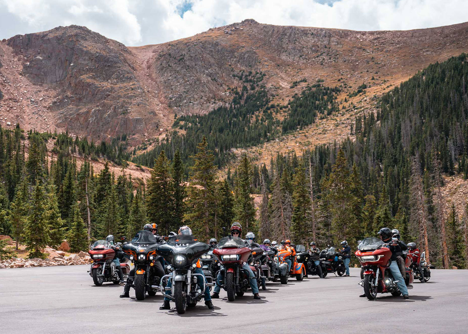 A large group of Harley-Davidsons assemble at a roadside turn-off during the ascent to the summit of Pikes Peak.