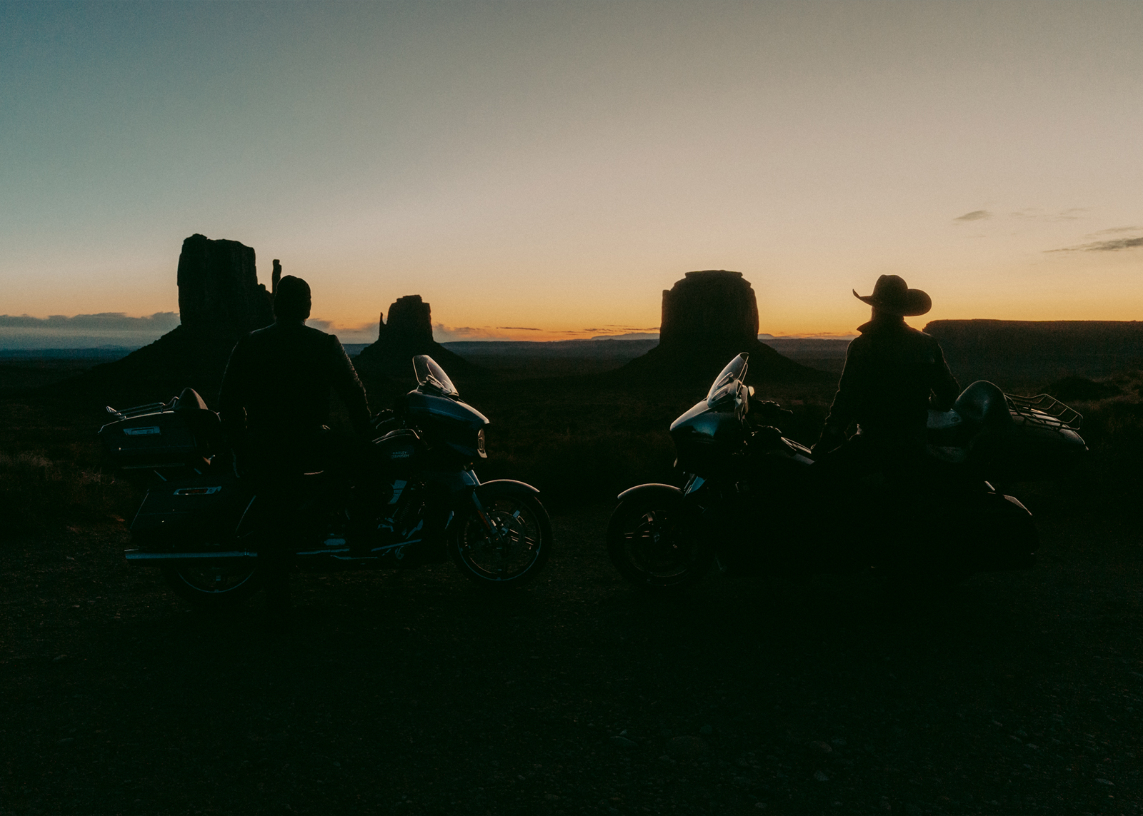 Two men with their bikes at sunset