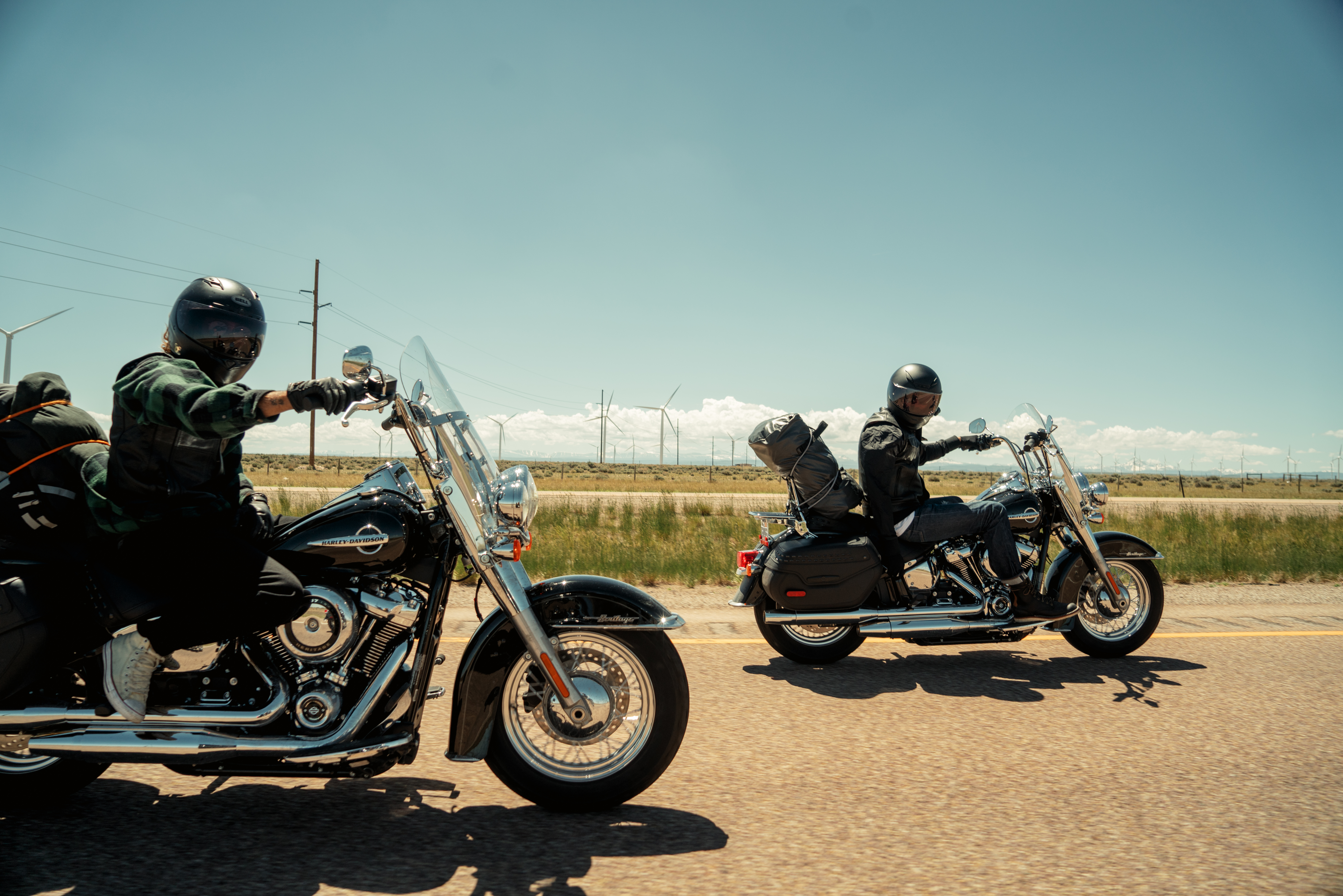 Deux motocyclistes sur des motos Harley-Davidson roulant sur une route ouverte