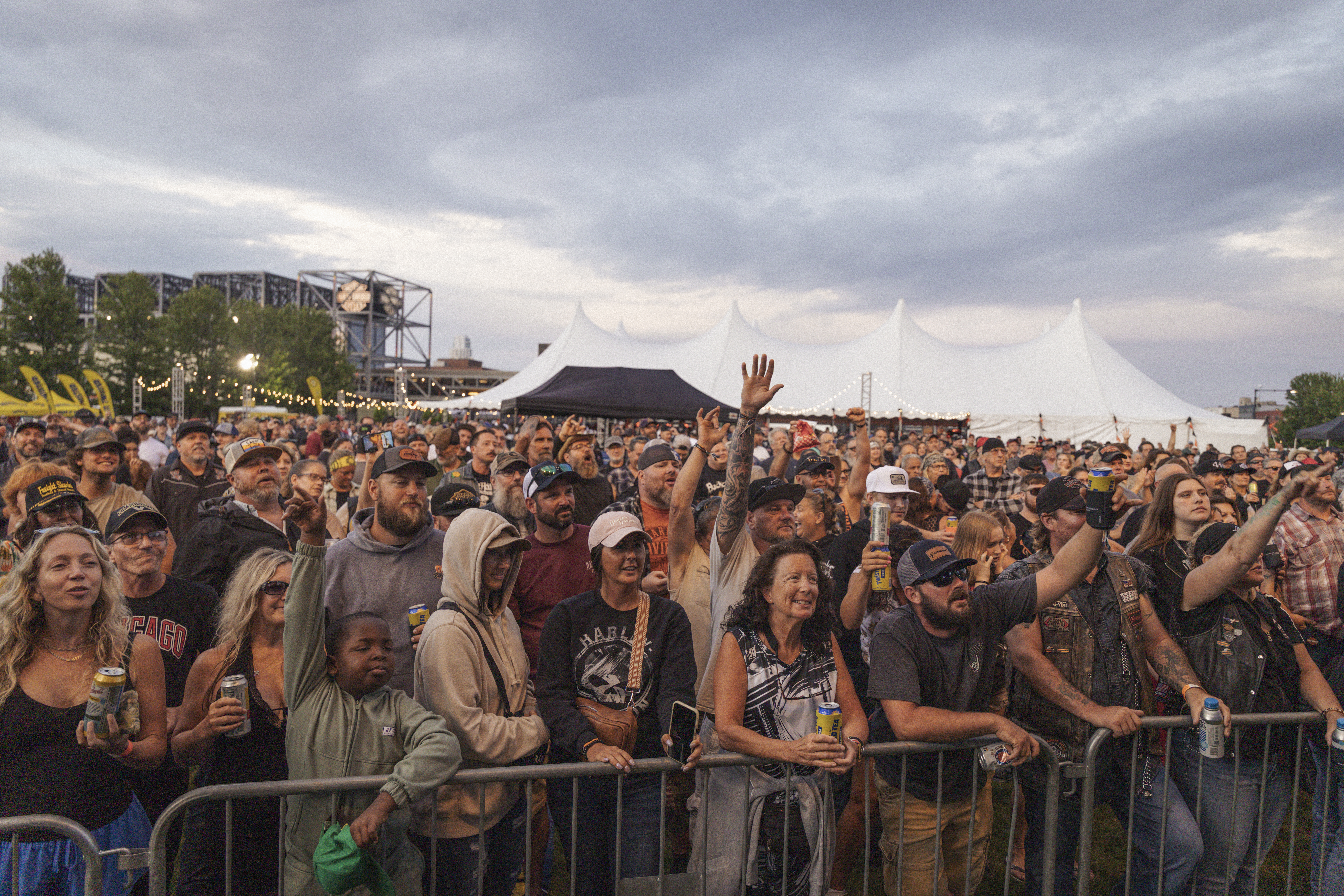 Gran multitud reunida en un concierto al aire libre detrás de una barricada